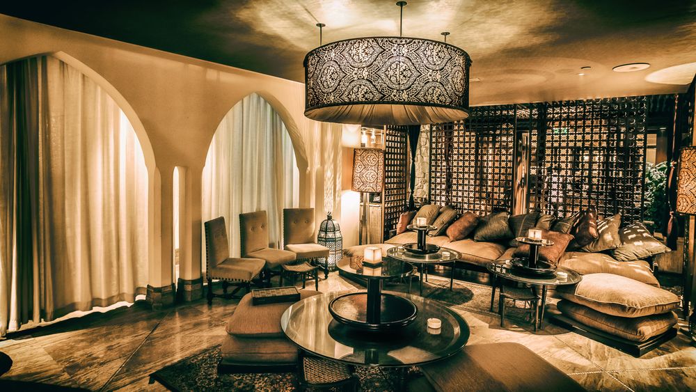 Luxurious lounge area with ornate chandelier and curved seating arrangements.