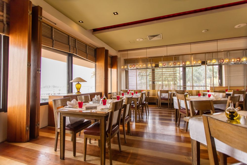 Bright restaurant dining room with large windows and wooden furniture.
