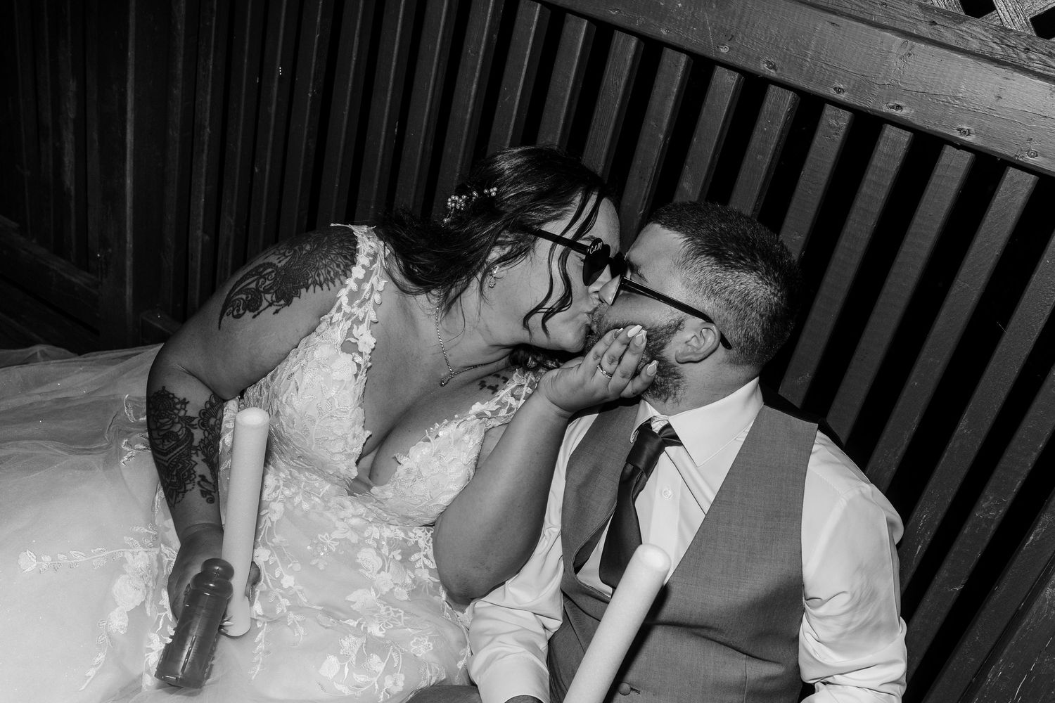 A tender black and white wedding moment captured between newlyweds in intimate lighting.