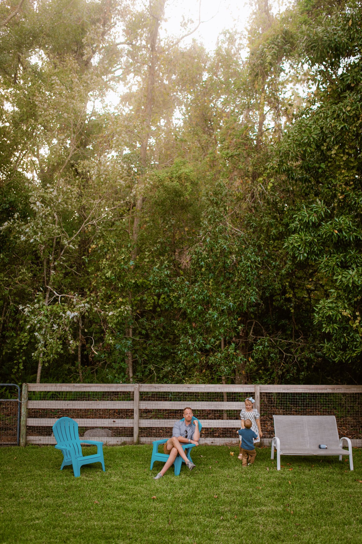 Two people sitting together outdoors while smiling, with one wearing a blue and white floral top and one in a blue shirt.