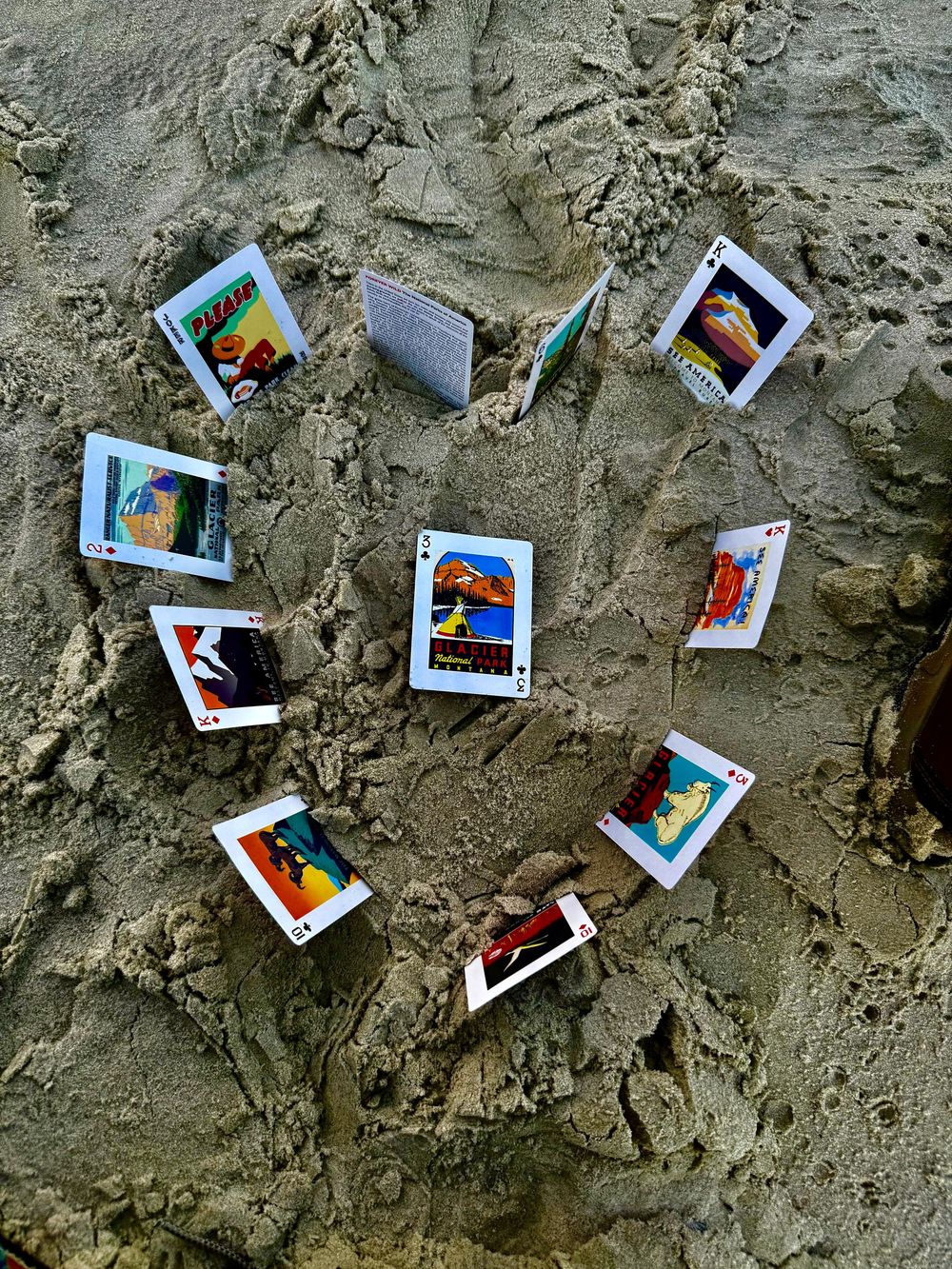 Multiple Polaroid-style photographs scattered on a sandy gray textured surface creating an artistic arrangement.