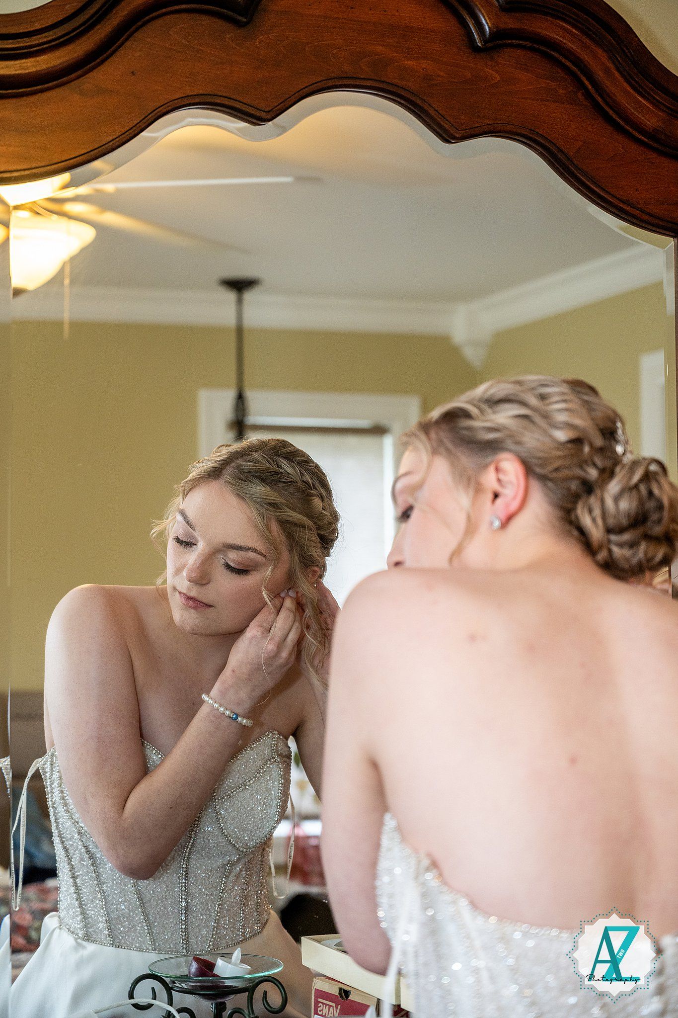 Bride gets emotional while having jewelry placed on her wrist during wedding preparations.