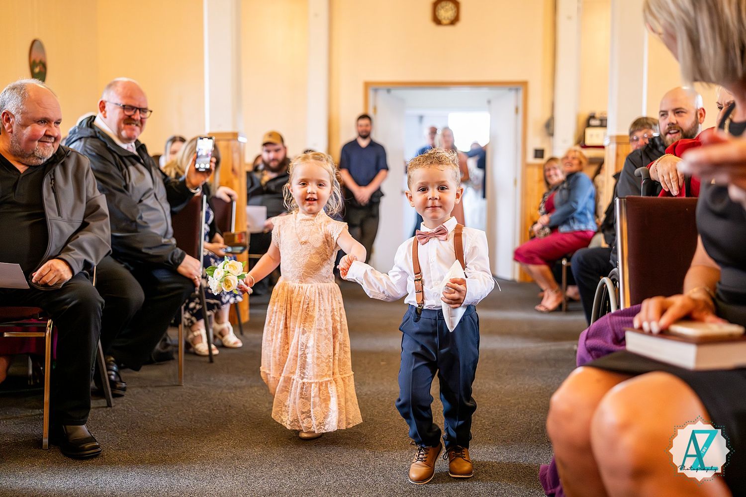 Wedding guests celebrate in a church hall during a reception.
