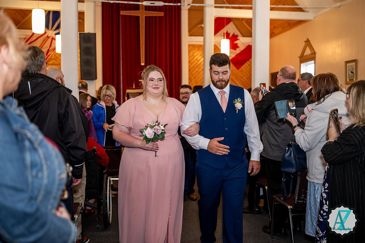 Wedding guests dance and celebrate together during a reception in an elegant indoor venue with warm lighting.