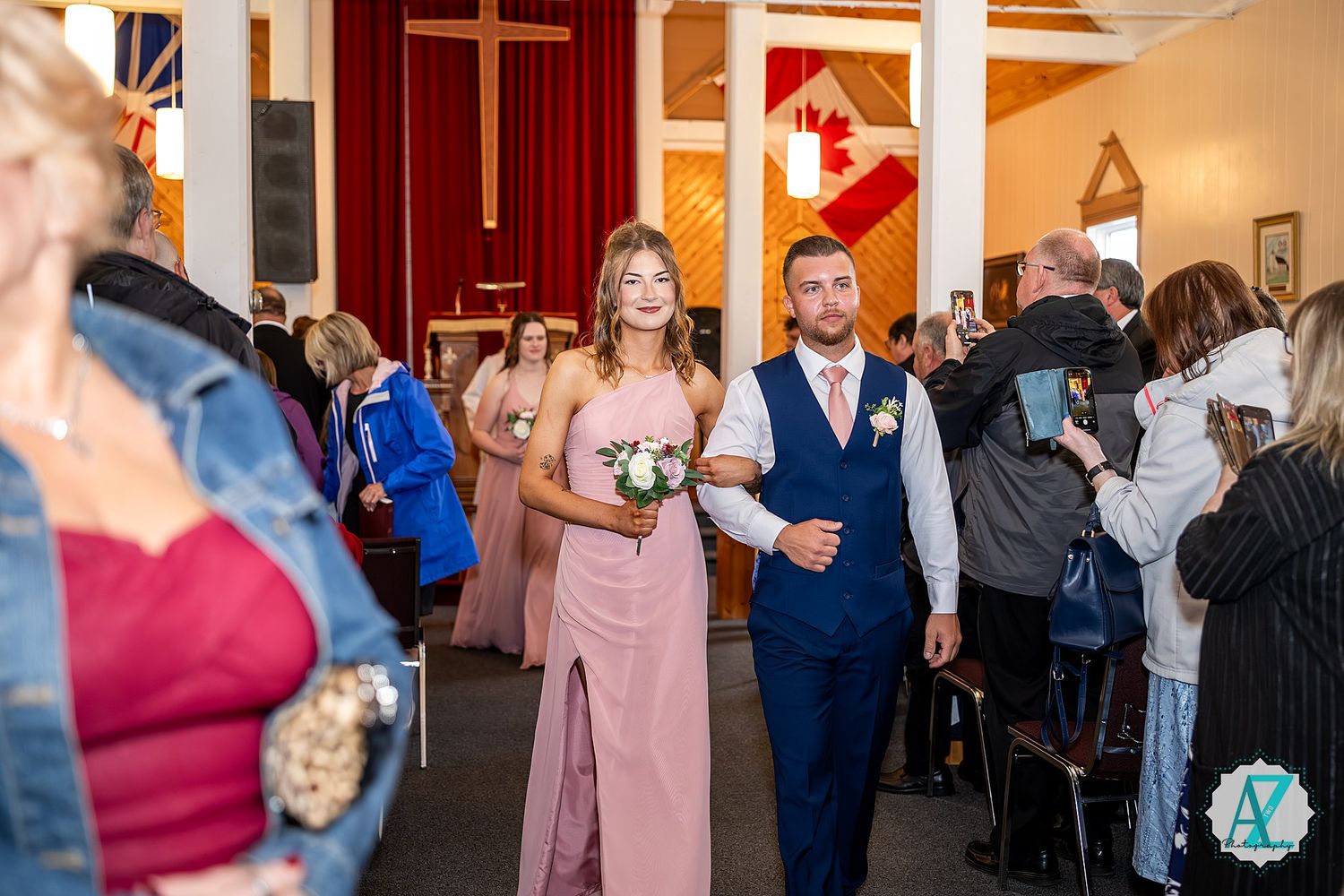 Wedding guests gather and dance together during a reception celebration in a church or banquet hall.