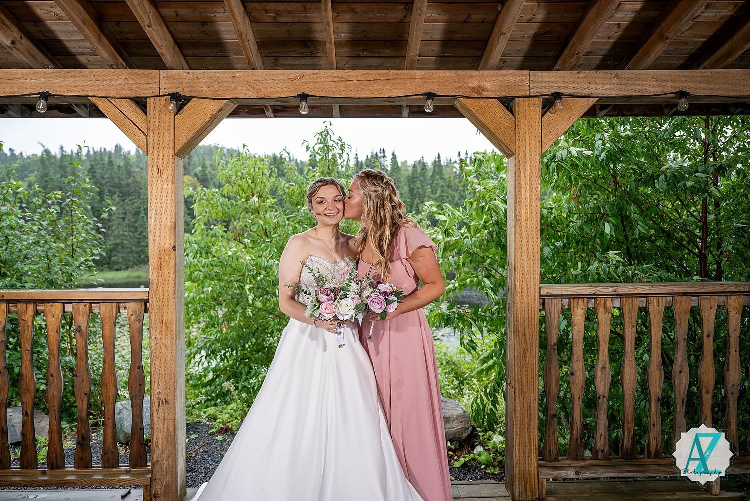 A beautiful outdoor wedding photo shoot under a rustic wooden gazebo with mountain views and lush greenery.