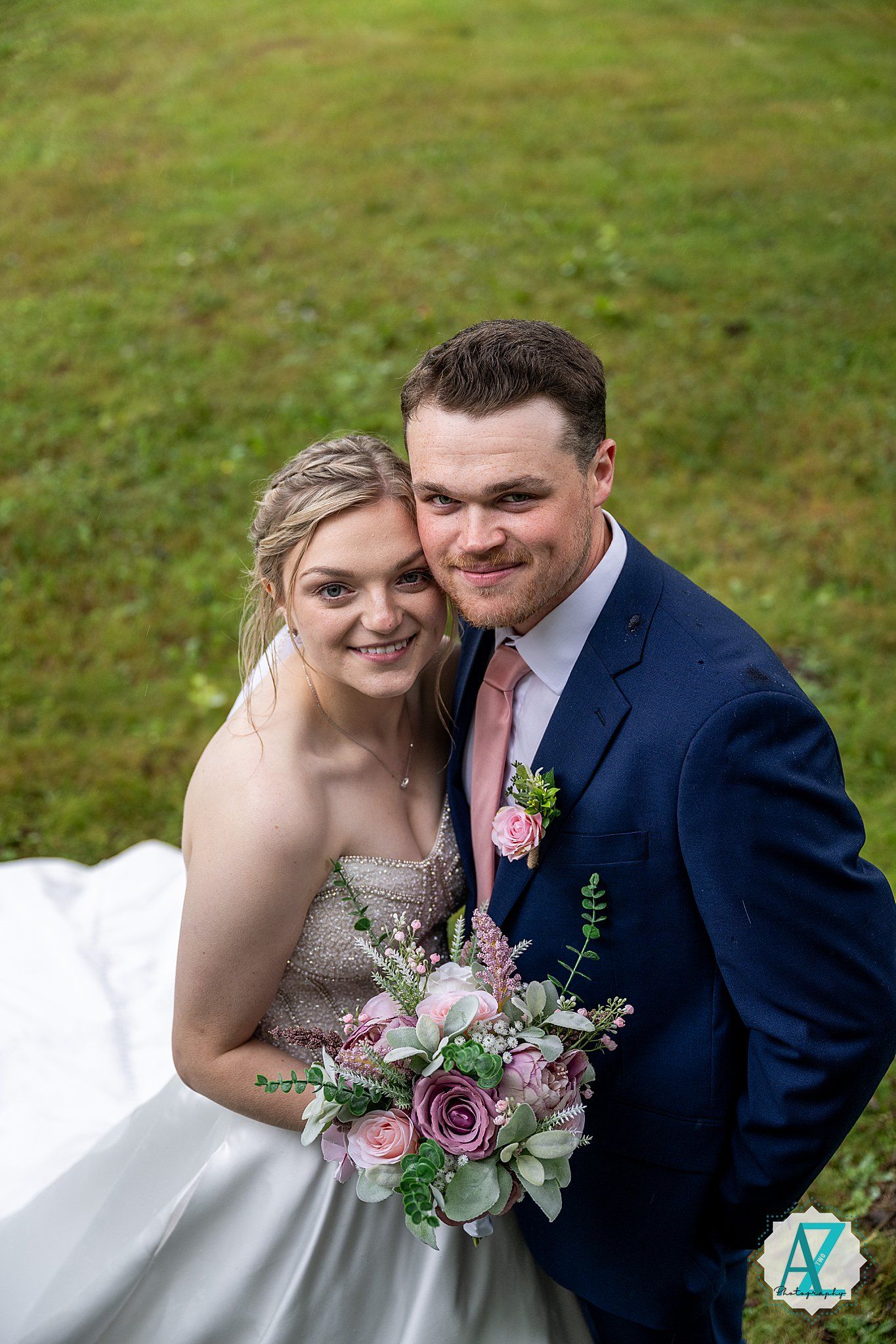 Wedding couple sharing intimate moments on the grass during outdoor garden wedding photoshoot.