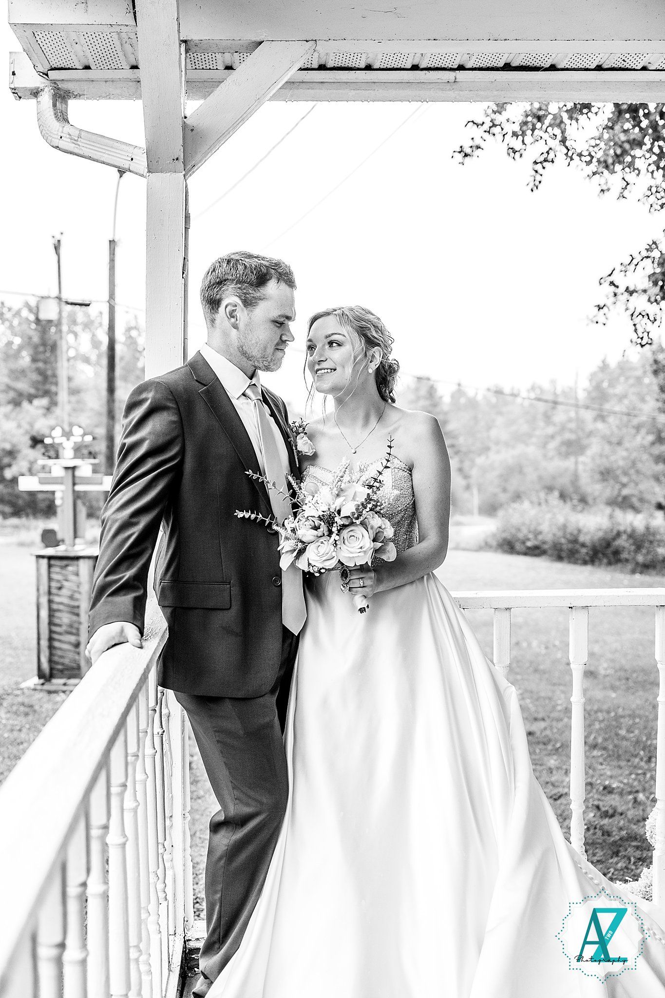 Black and white wedding portraits captured on a rustic white porch showing intimate moments.