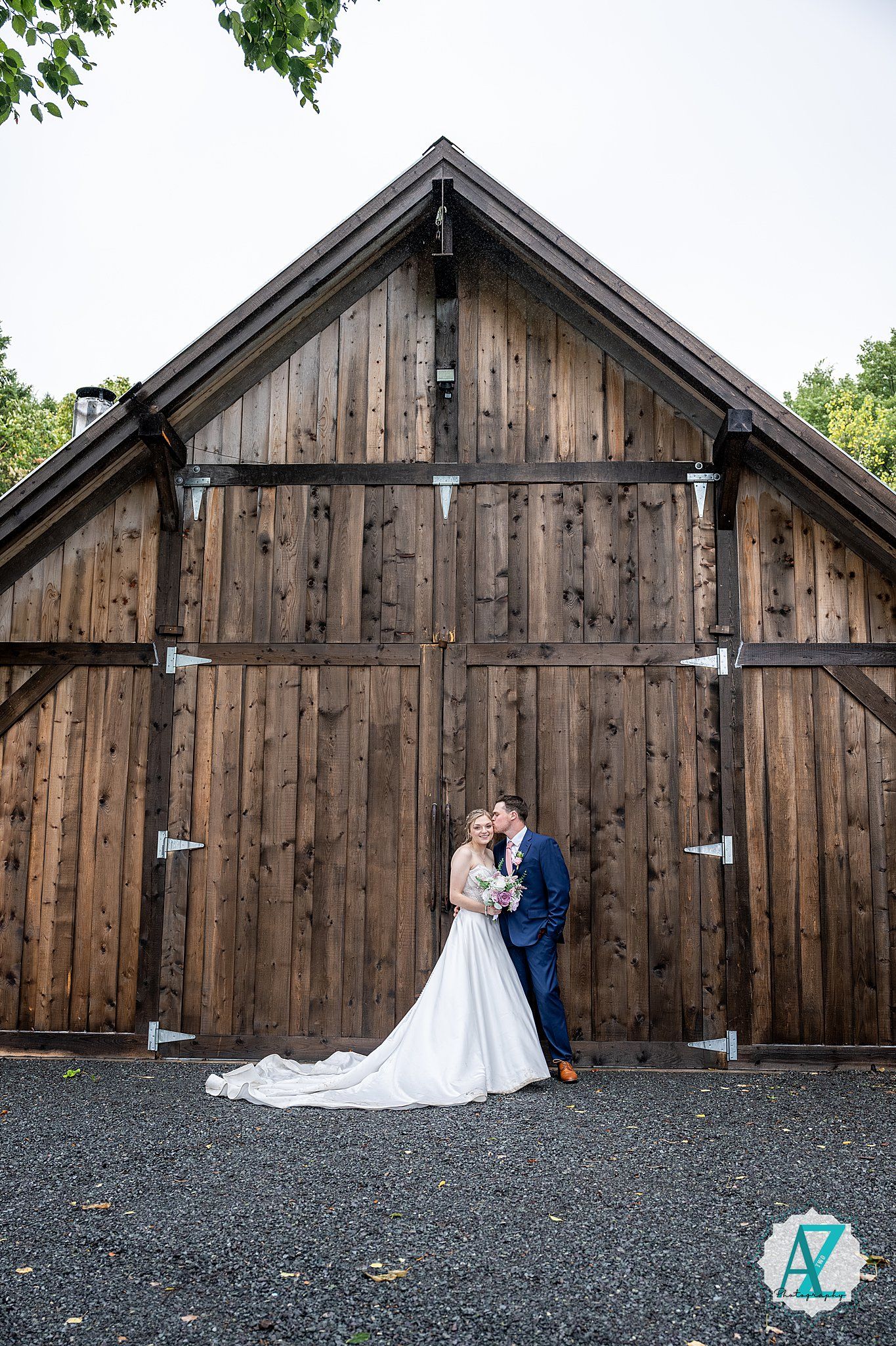 A wedding photo sequence against a weathered wooden barn showing romantic couple portraits on a dark gravel surface.