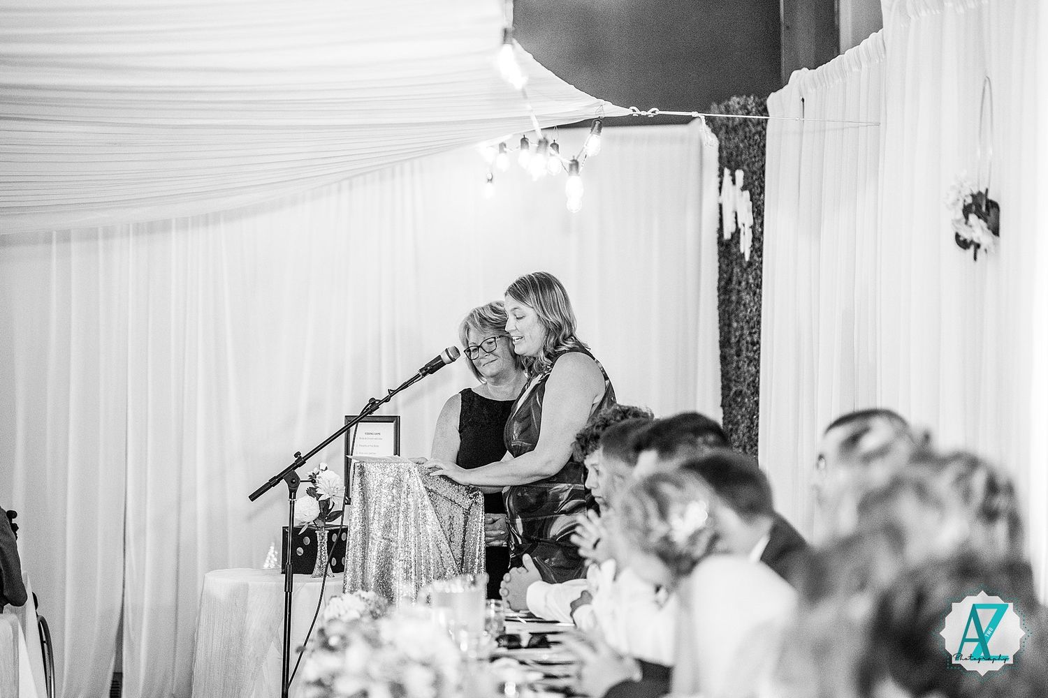 Black and white photograph of guests mingling at a formal gallery reception event.
