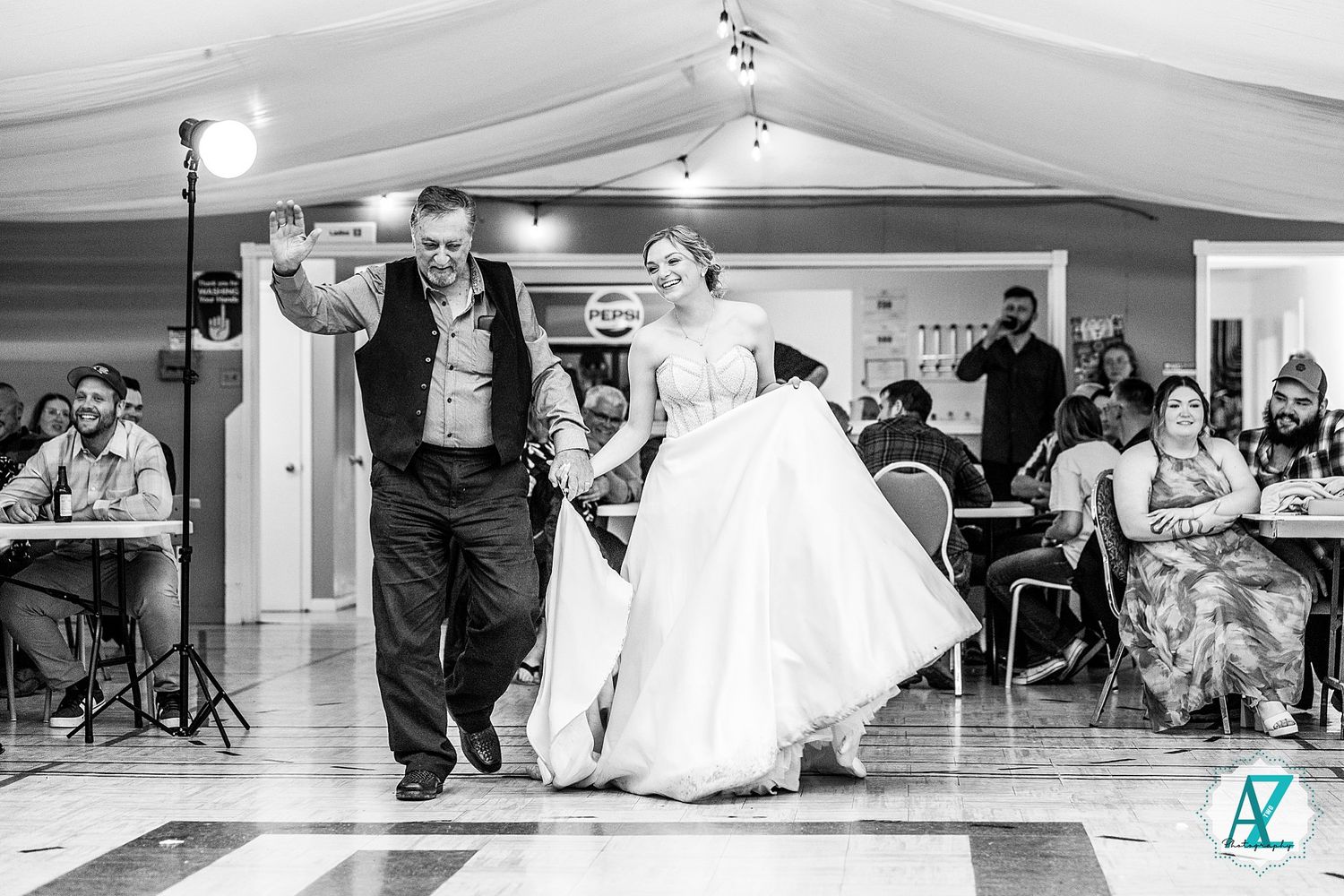 A couple performs a dramatic dip during their wedding dance in an elegantly decorated reception hall.
