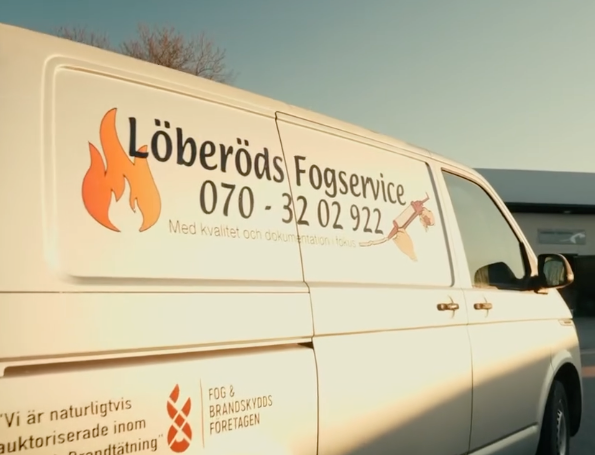 White commercial vans parked in a row displaying company logos and contact information.