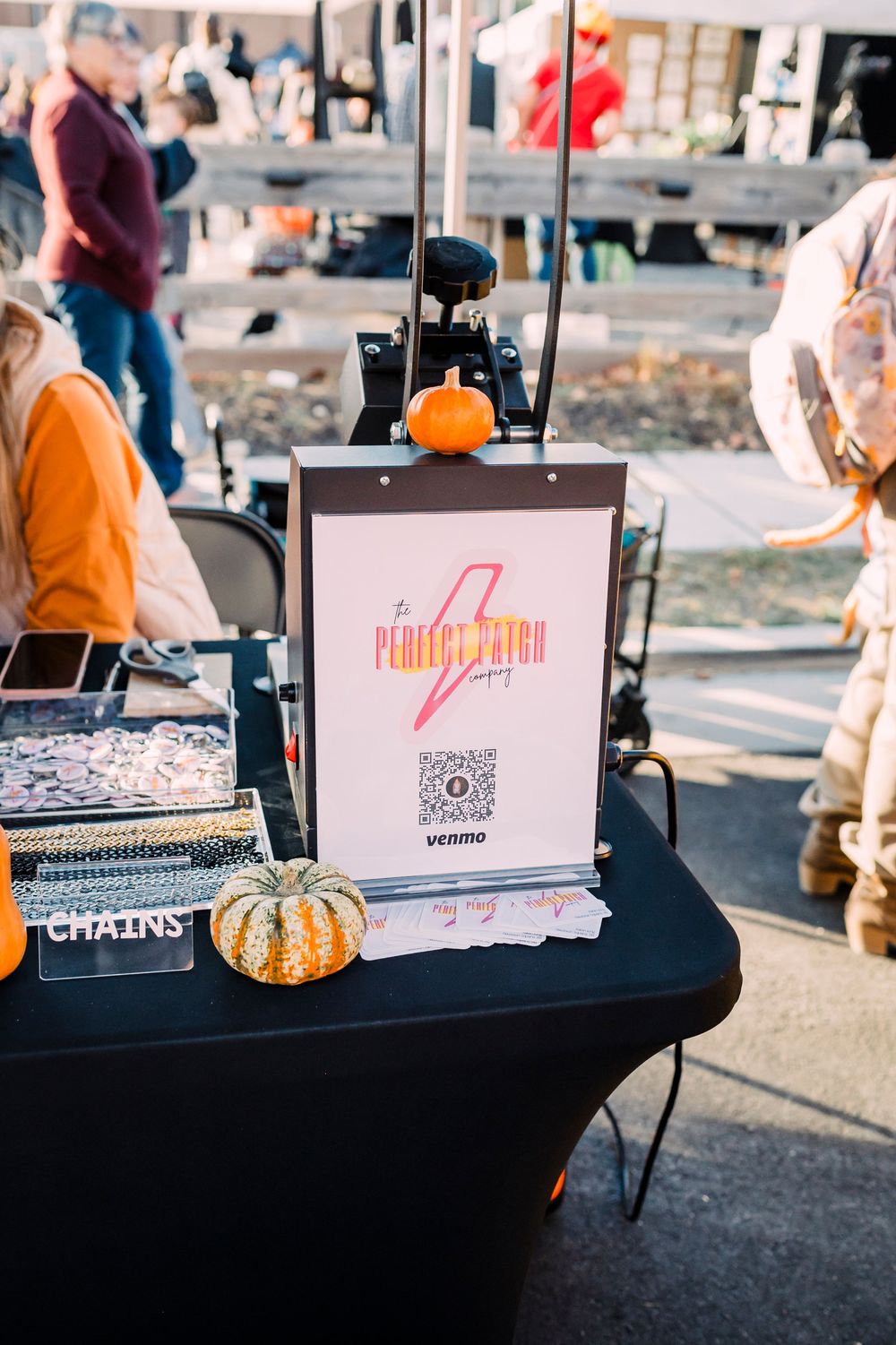 Vendor table at an outdoor market displaying business cards and promotional materials.