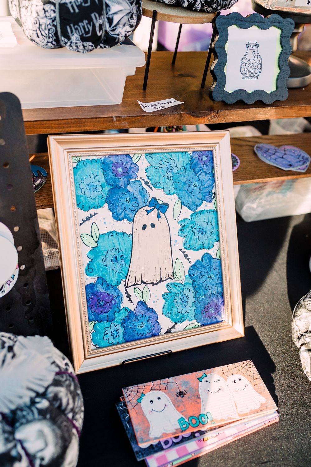 Framed artwork featuring a cute ghost illustration with blue floral patterns in watercolor.