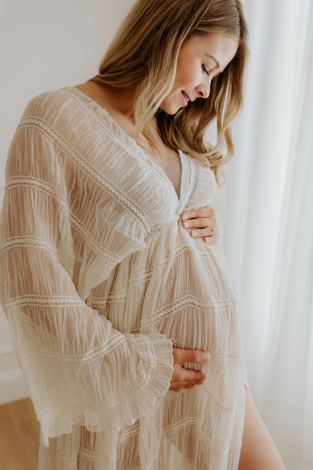 Pregnant mama to be modelling a flowing gown in a Tea Tree Gully photography studio for her maternity photo shoot.
