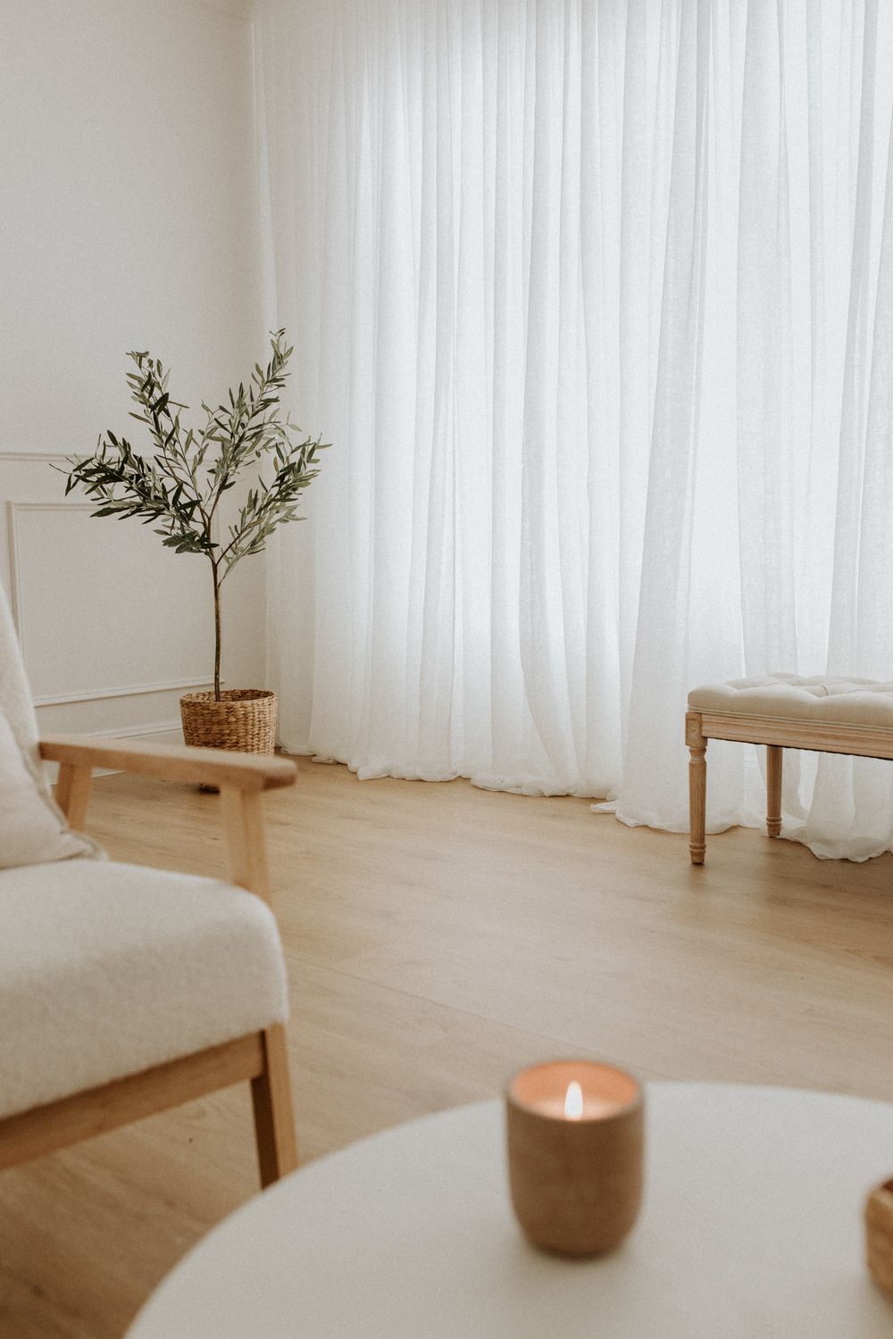 A candle burns in a bright Adelaide photography studio with natural light and minimal styling ready to host a newborn photo session.