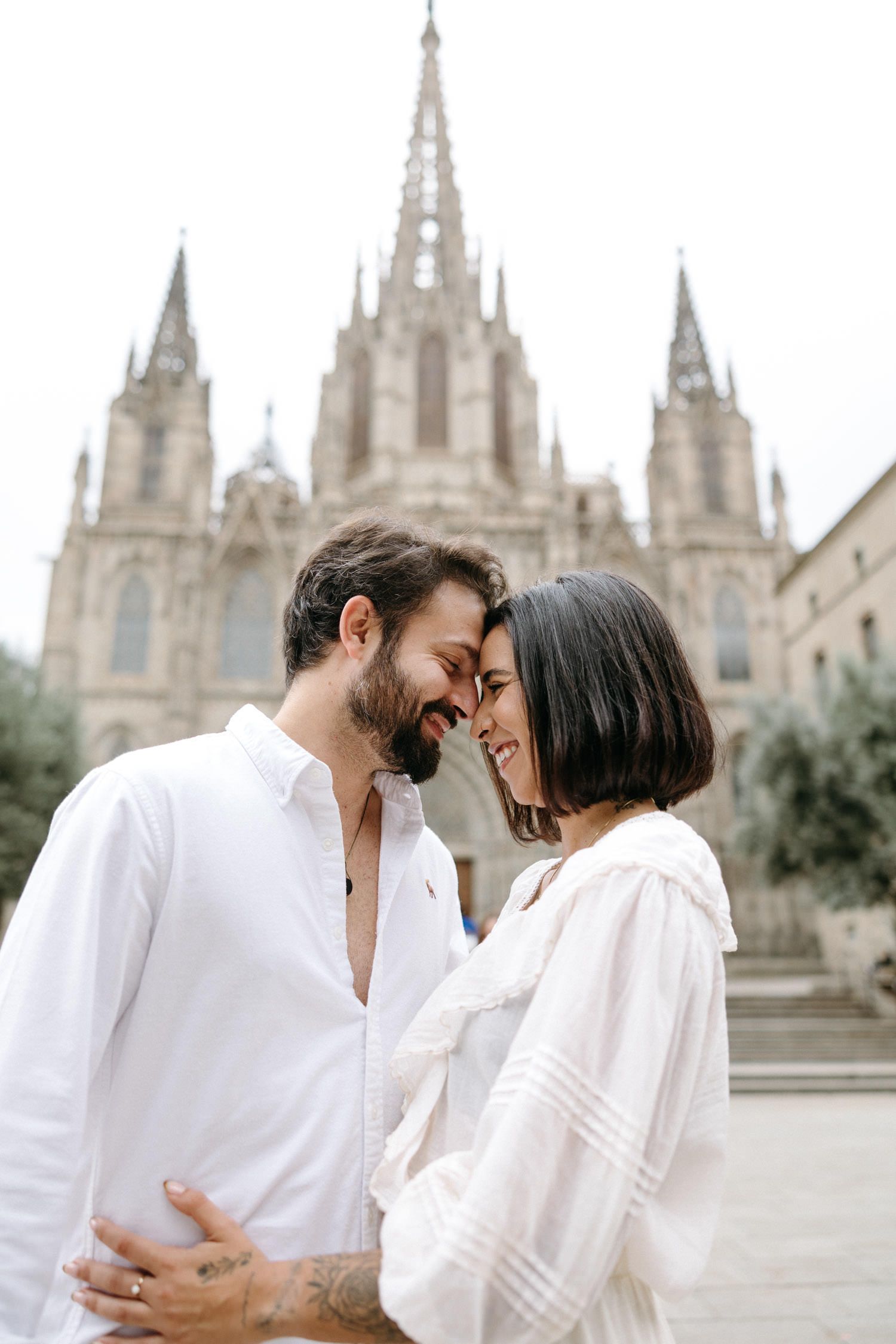 A series of intimate photos with a couple in white outfits against a cathedral backdrop.