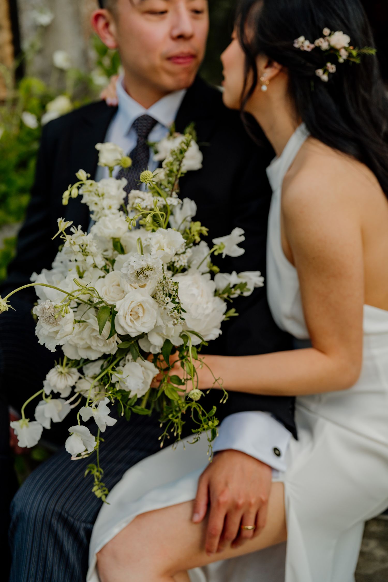 Close up shot of elegant white wedding bouquet with roses and delicate flowers.