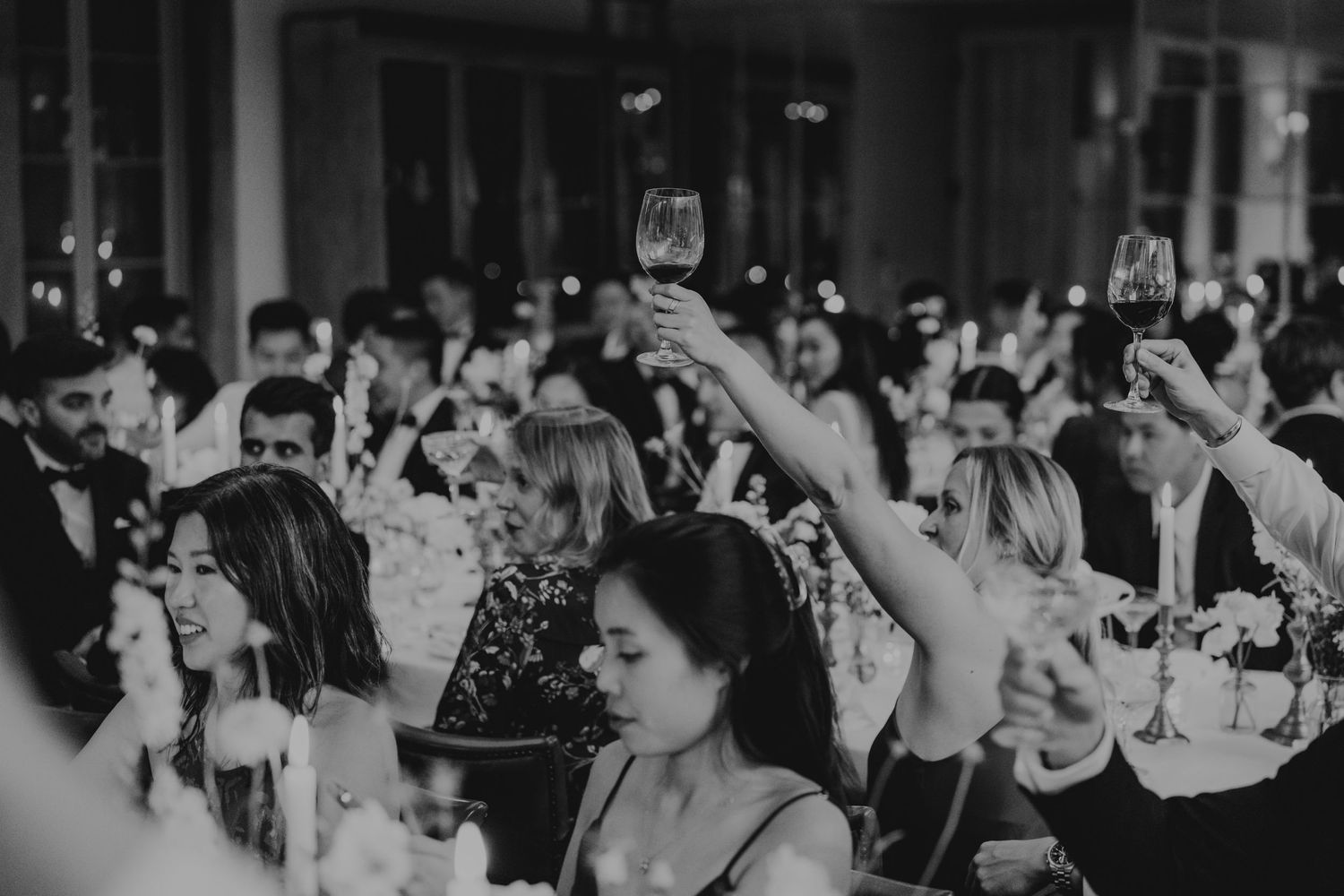 Large crowd of wedding guests celebrating on a dance floor during reception party.