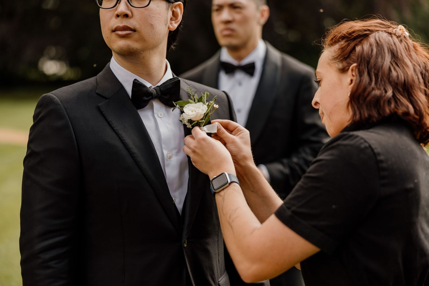 Wedding scene with people sharing emotional moments and embraces during an outdoor ceremony.
