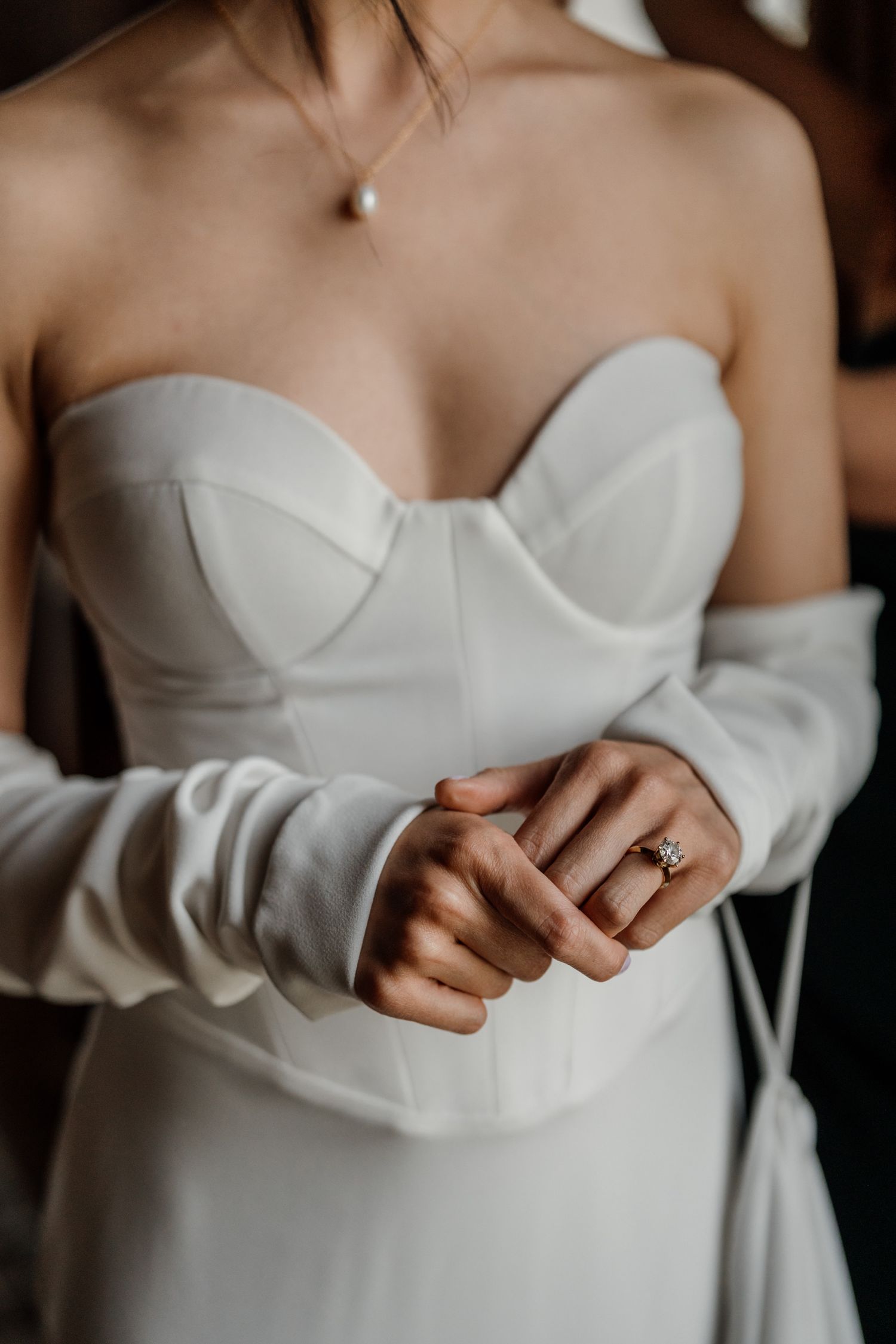 Close-up detail of a white strapless wedding dress bodice with delicate ruching.