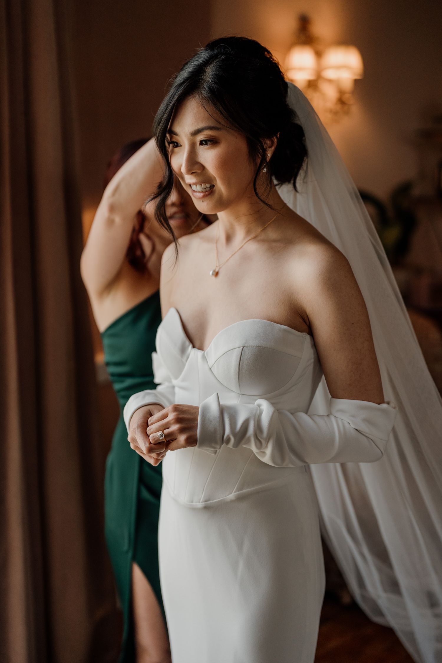 Intimate getting ready moments with soft lighting and delicate white wedding dress details.
