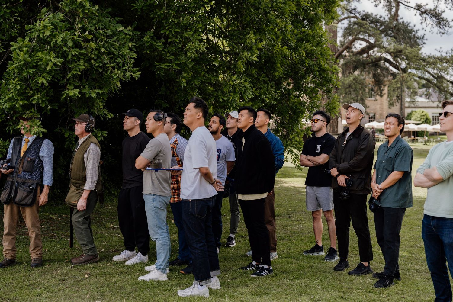 Group of casually dressed guests lined up outdoors at event.