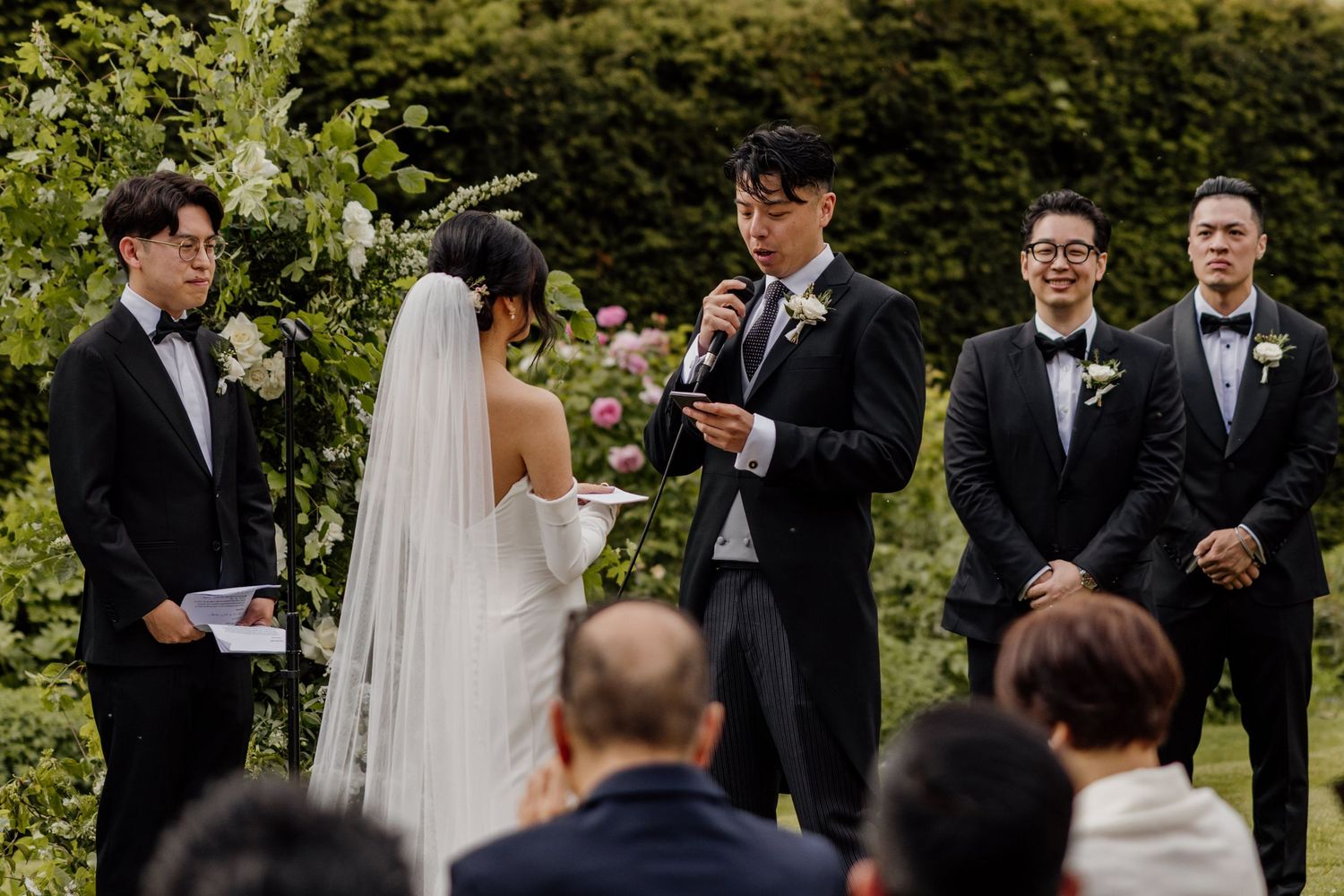 Wedding party members share joyful moments during an outdoor celebration.