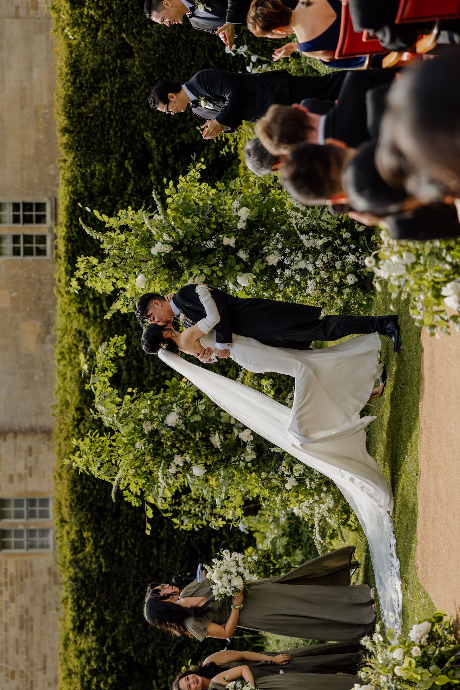 Wedding guests gathered on a lush green lawn for an outdoor celebration.