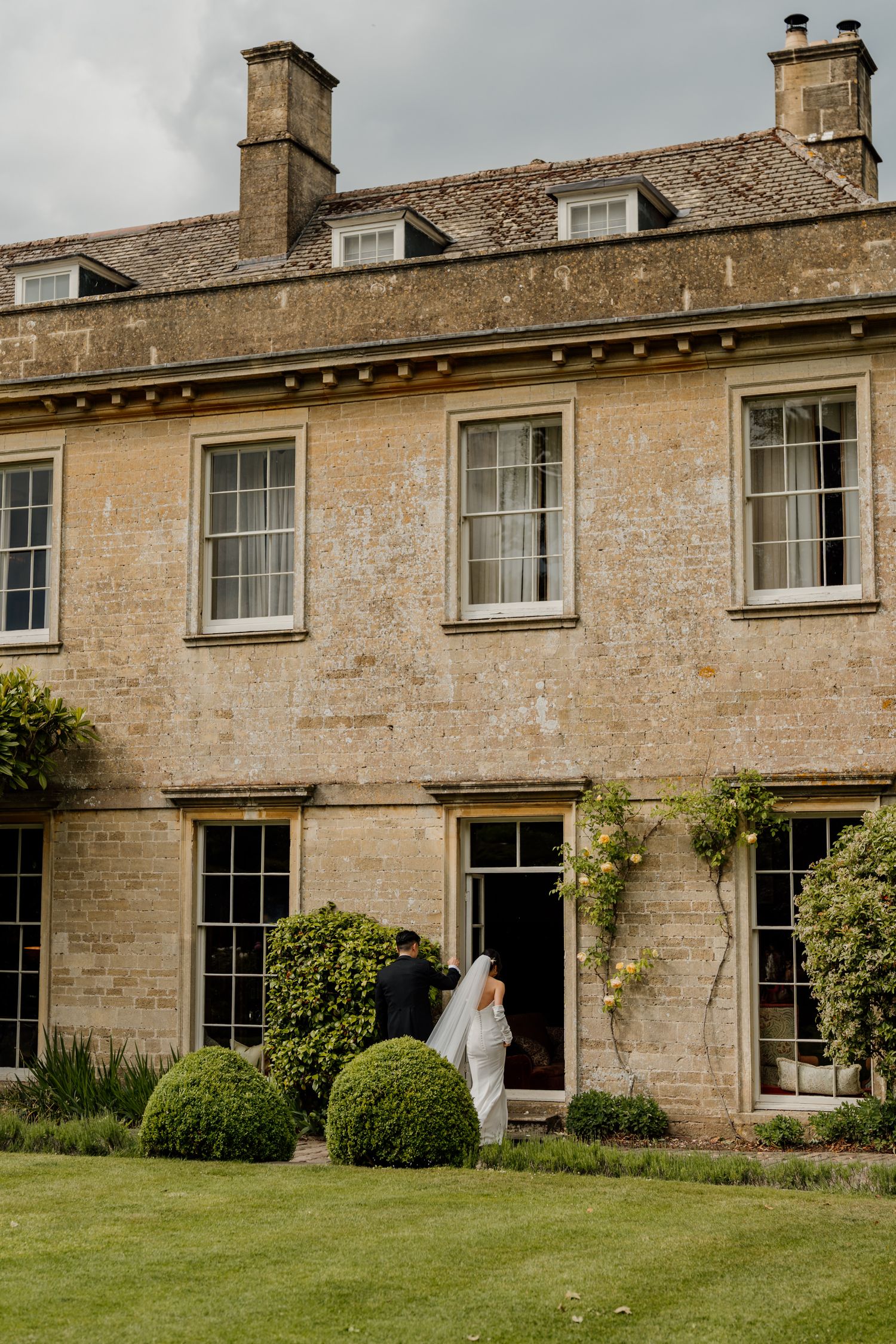 Exterior view of a grand Georgian manor house with symmetrical windows and manicured lawn.