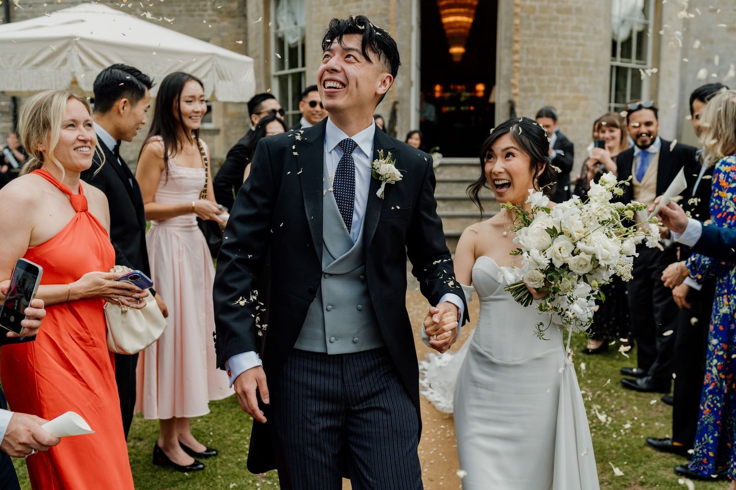 Wedding celebration on a terrace with white floral arrangements and elegant decor.