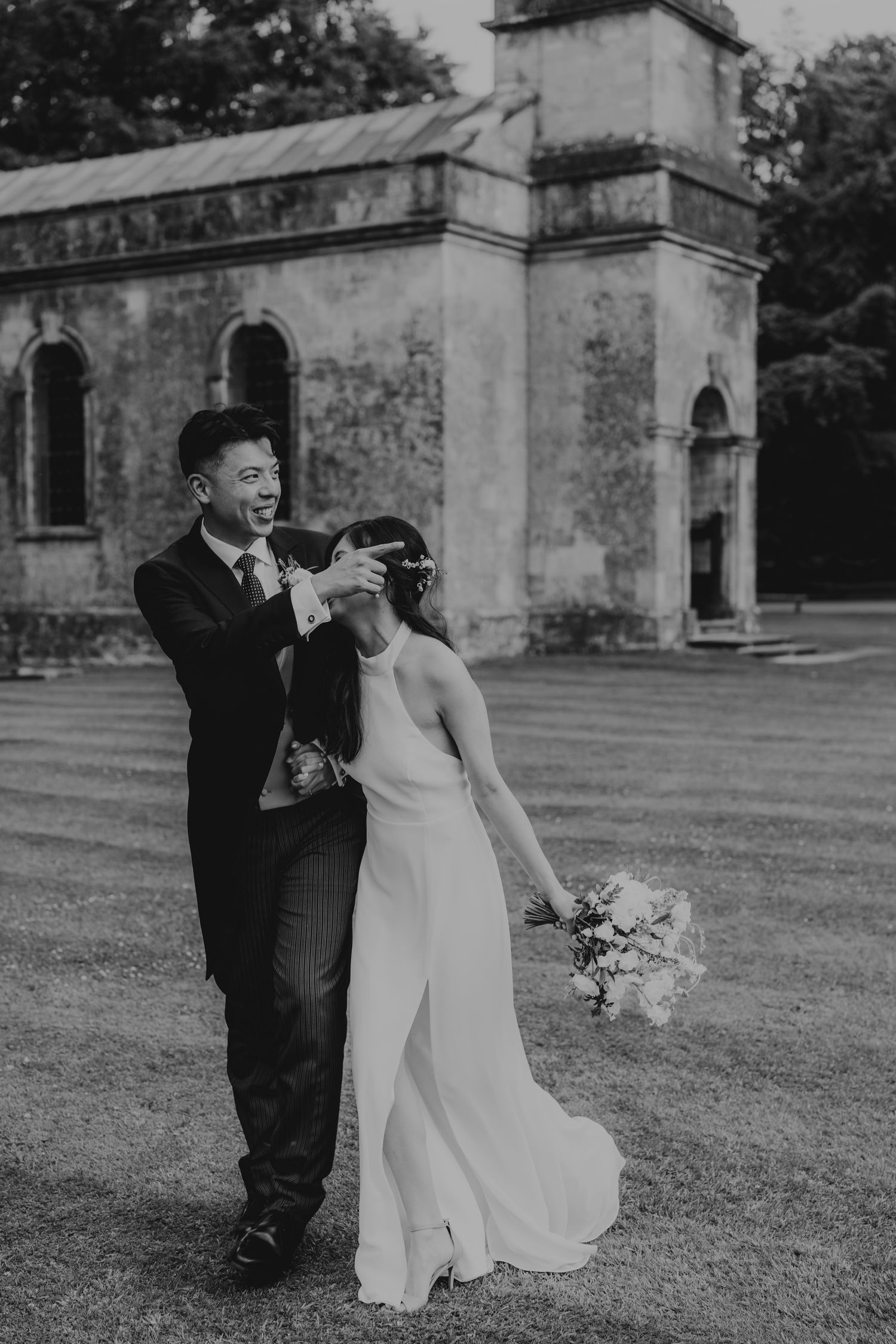 A couple shares romantic moments in a series of black and white photos outside a historic stone building.