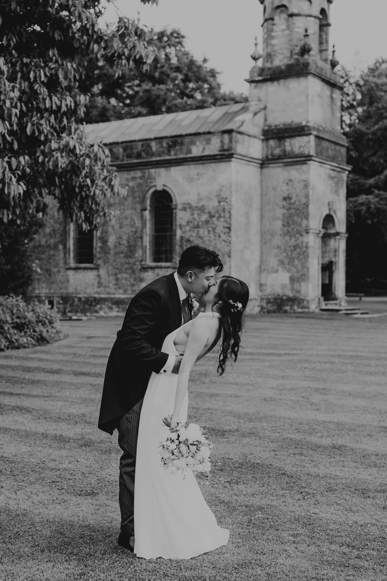 Black and white wedding photos captured outside a historic stone church.