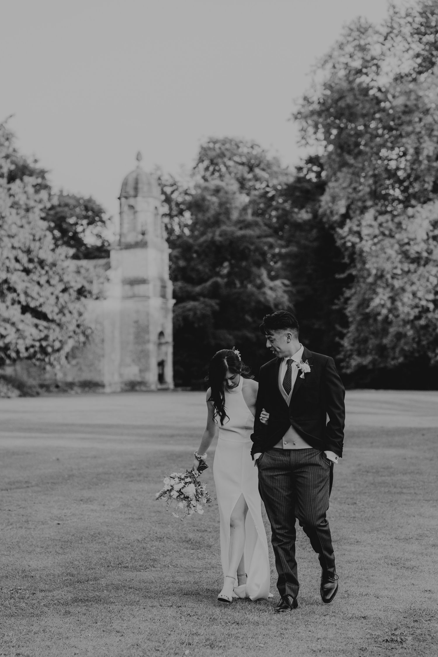 Black and white photos show a couple walking together in a garden setting during their wedding celebration.