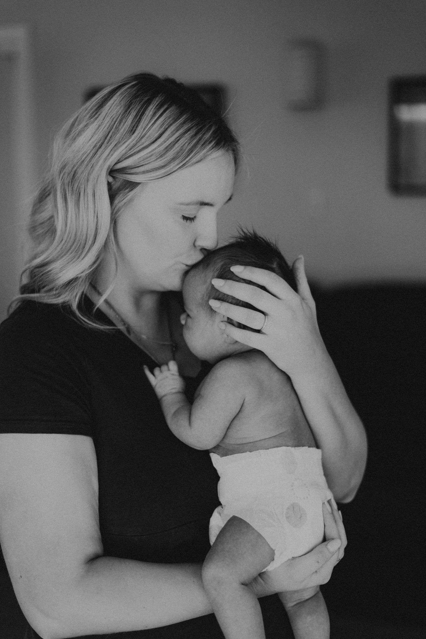 Black and white image of tender moment between parent and infant.