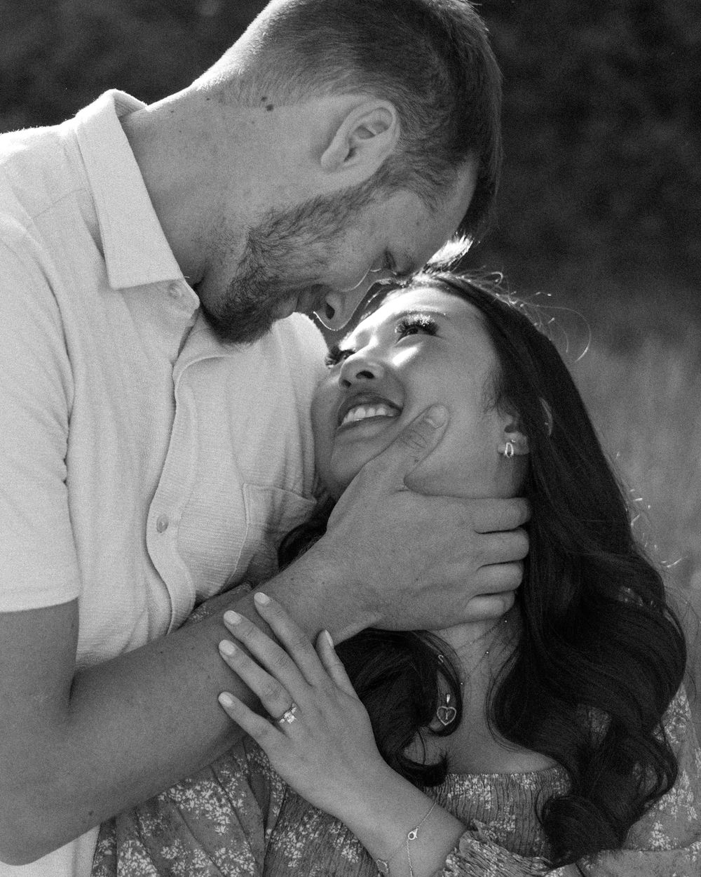 A romantic black and white photo of a loving couple sharing an intimate moment together outdoors.