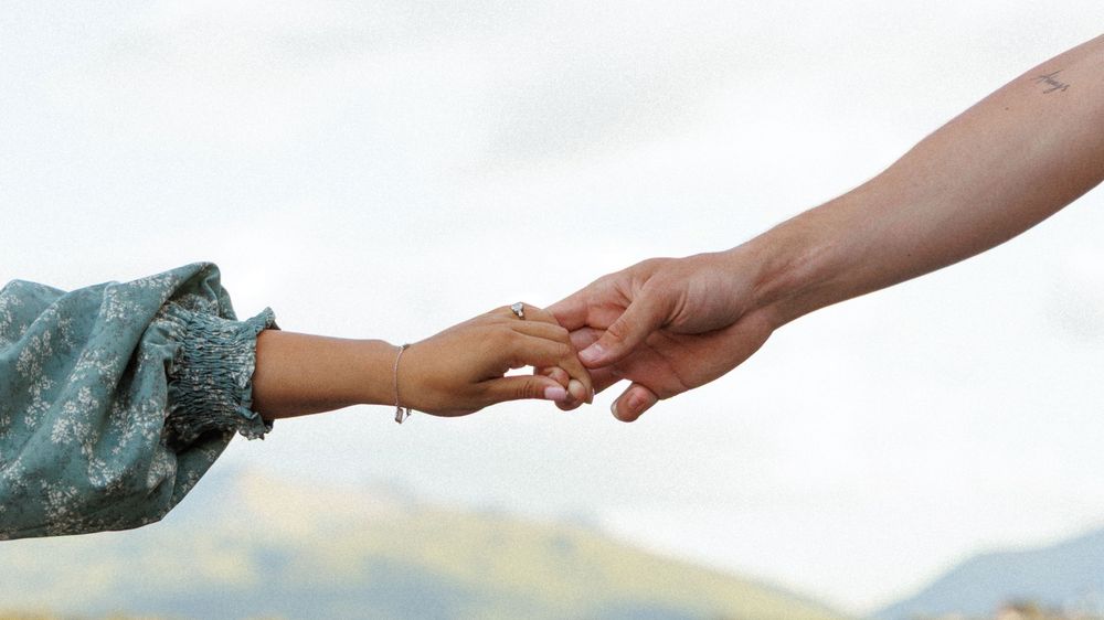 A gentle handshake silhouetted against a bright sky background symbolizes partnership and connection.