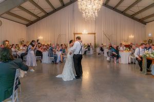 Bride and groom first dance under a chandelier  at Whispering Willow