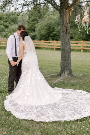 Bride and groom under tree with chandelier at sunset, Whispering Willow wedding photography. True to life timeless wedding photos.