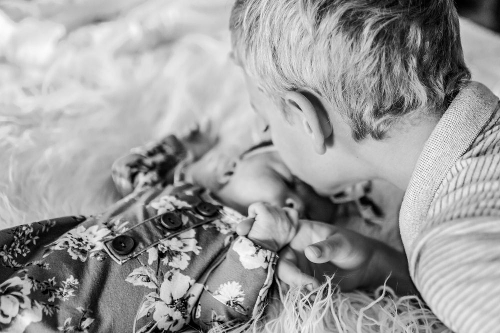 brother kisses baby sister in Fort Worth in-home photoshoot
