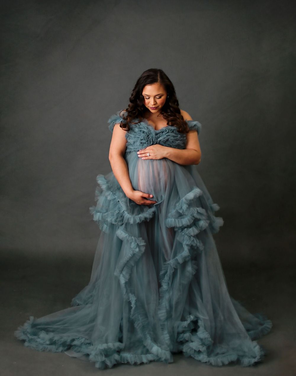 Pregnant mama holding her belly in studio