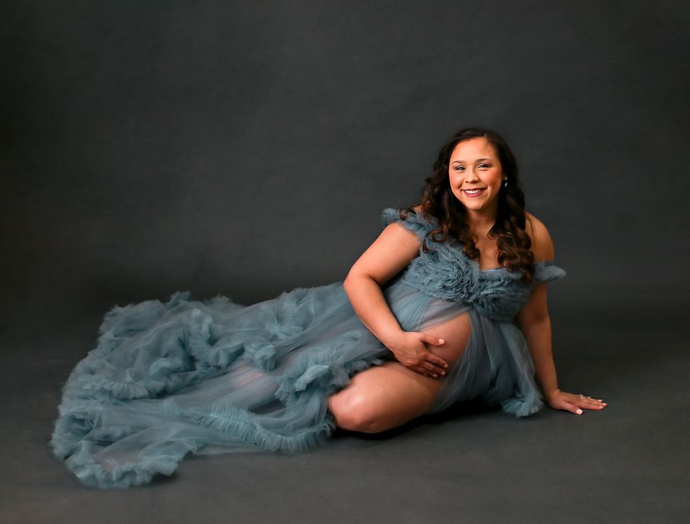 Pregnant mama laying on her side posing for maternity session in LD Molina Photography studio in Angleton Tx