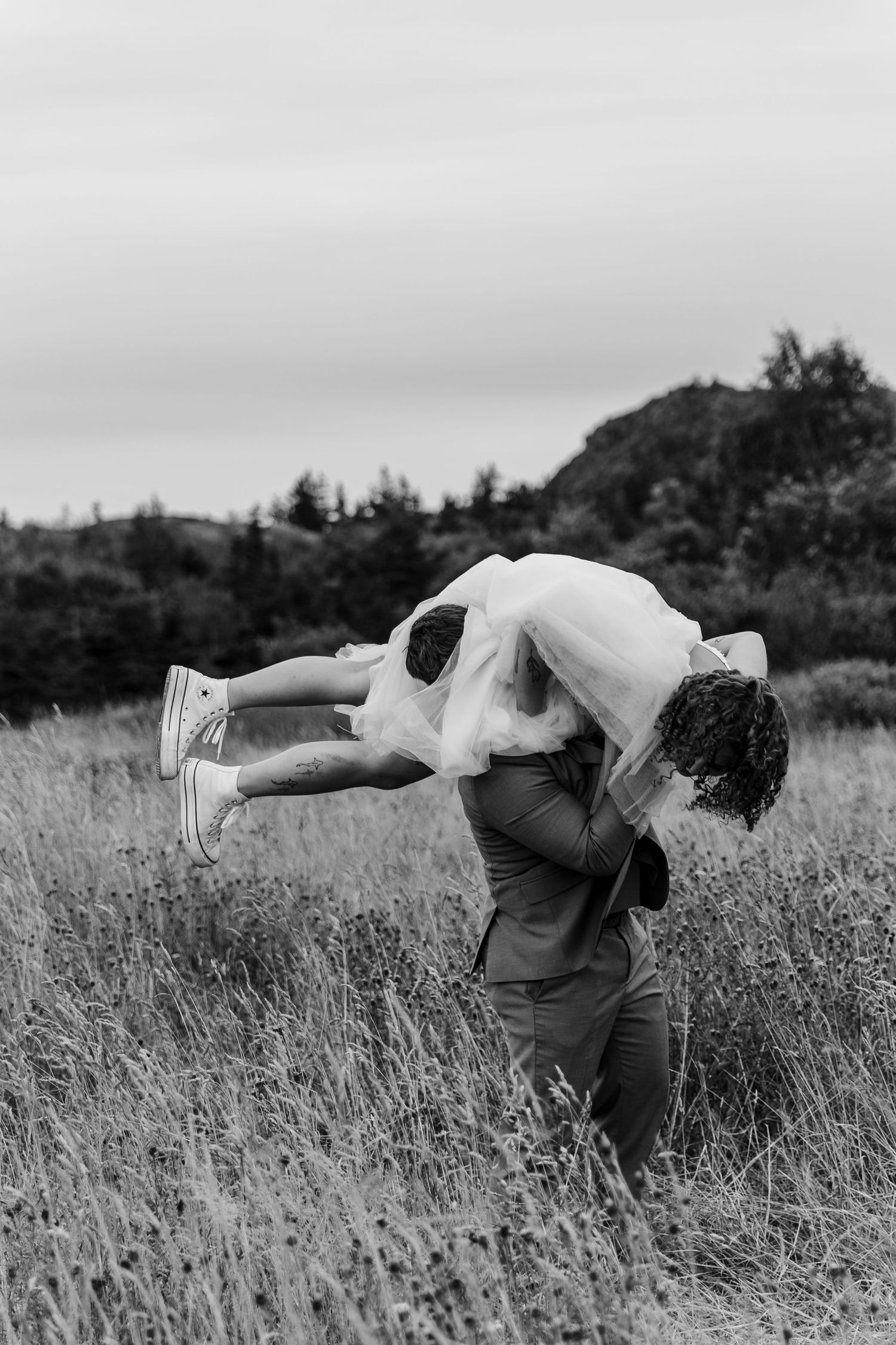 A black and white photo sequence showing a person performing graceful dance movements in a grassy field.