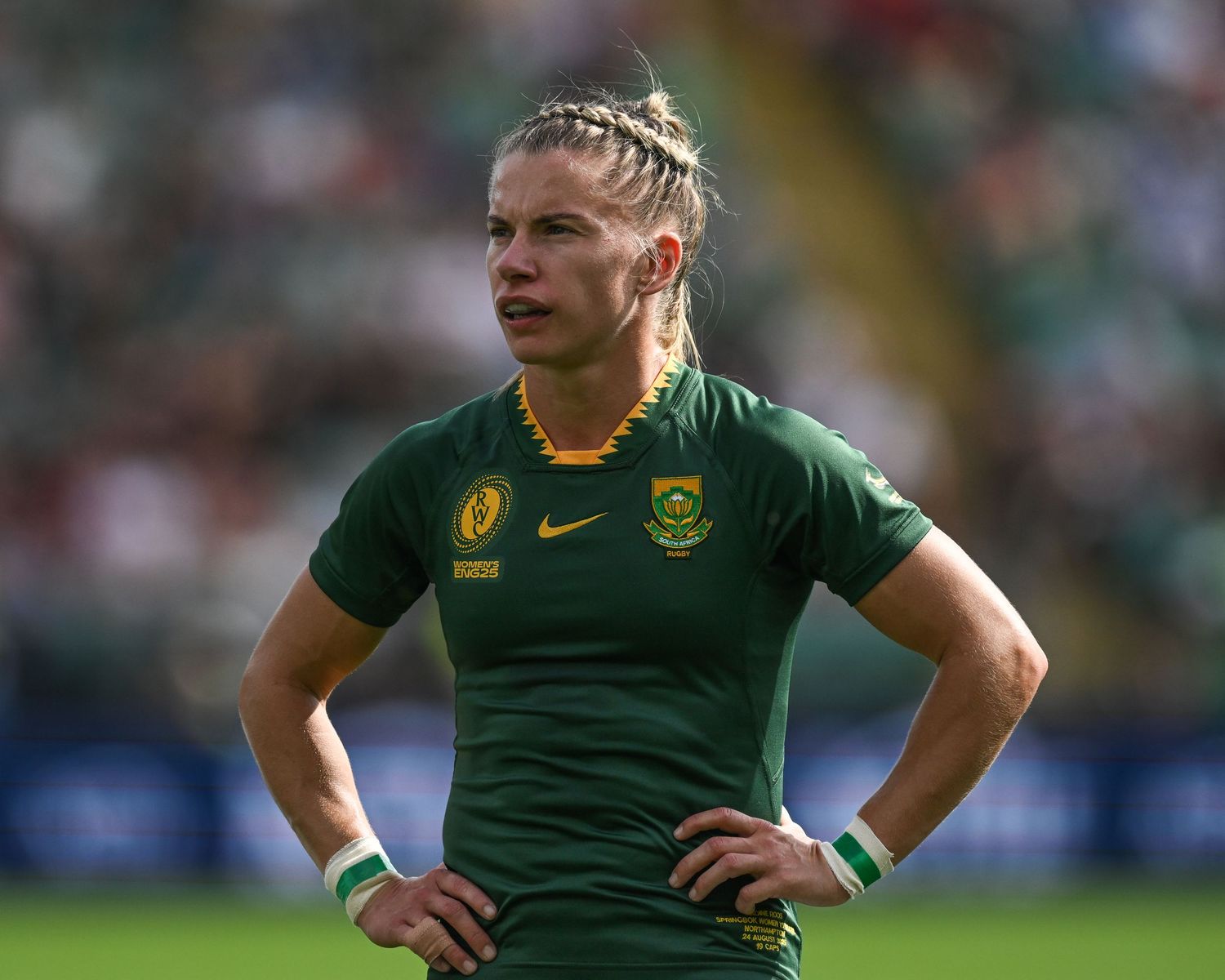 Rugby player in South African Springboks green jersey stands with hands on hips during match.
