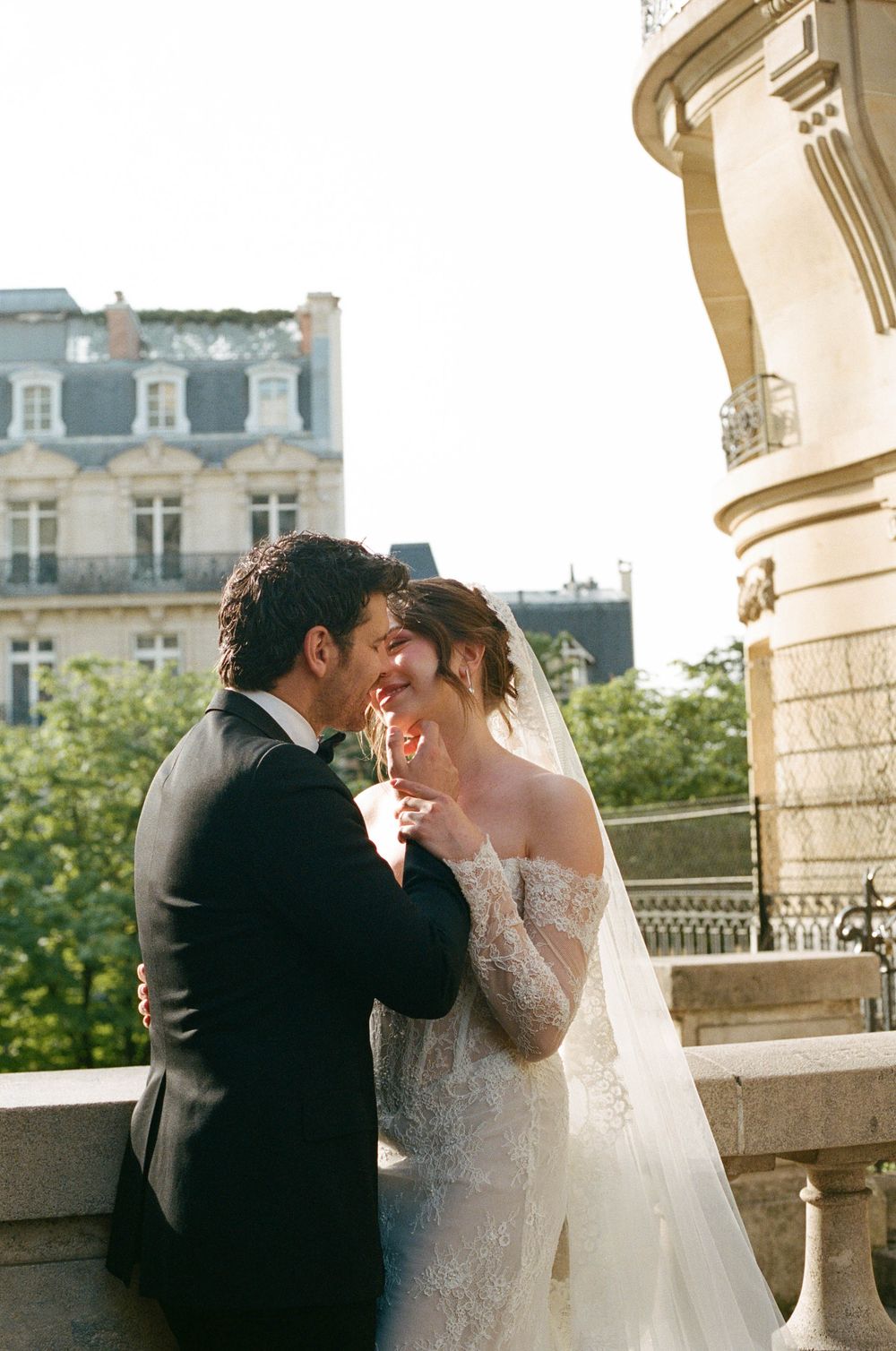 A romantic balcony scene from a wedding in Paris with elegant architecture and natural lighting.