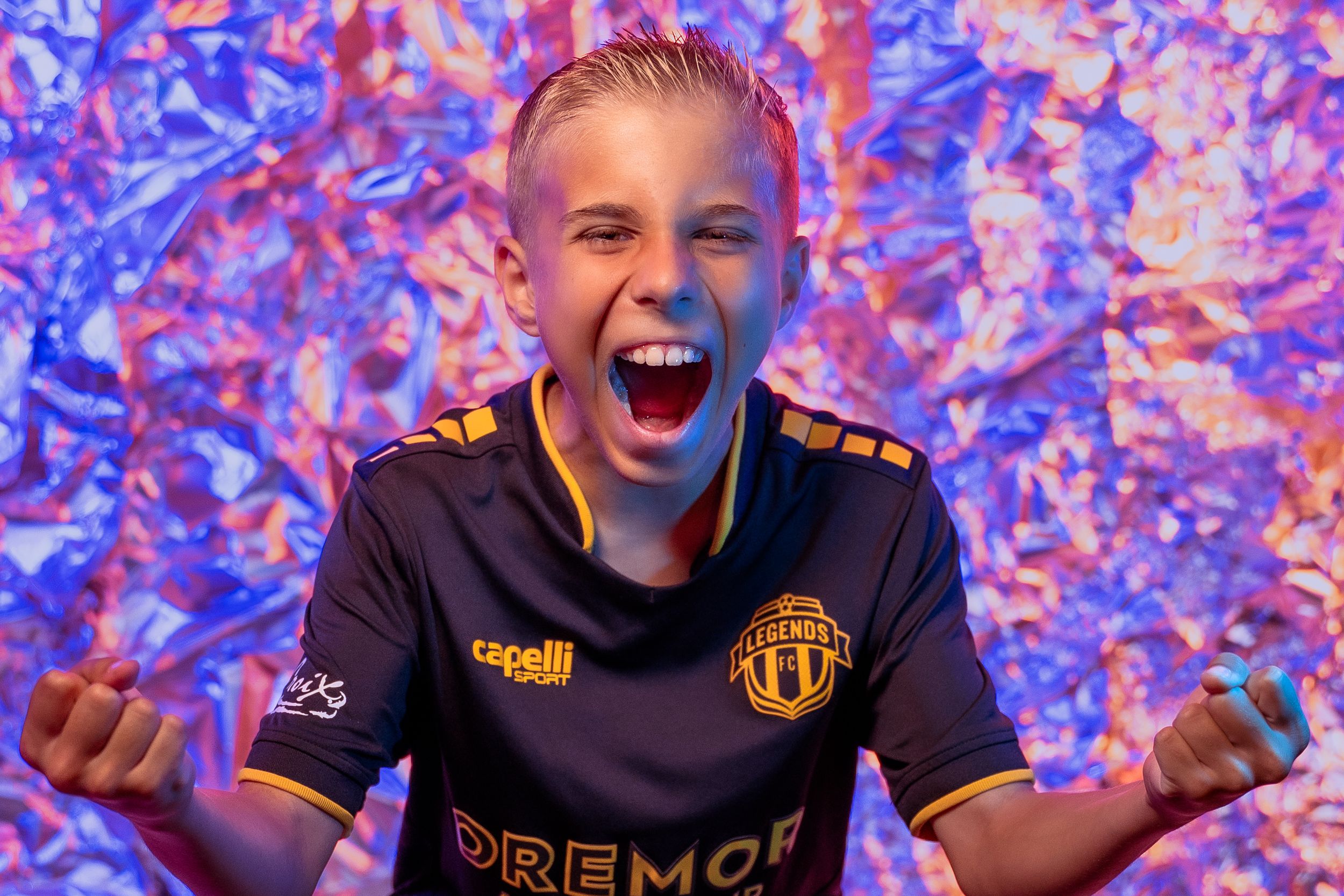 Energetic sports poses in black and gold Legends FC uniform against colorful background.