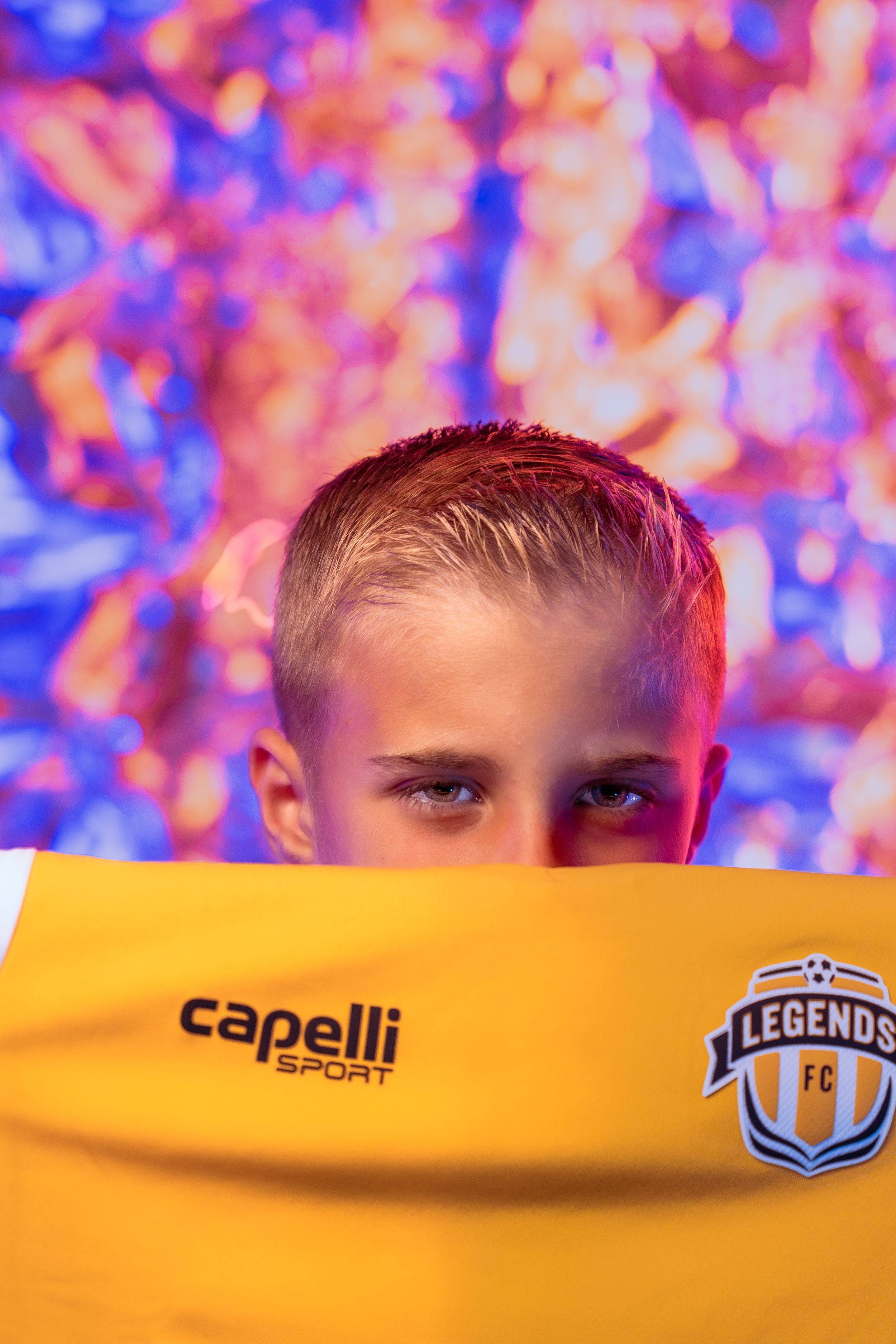 Sports portrait with Capelli Legends branding visible against vibrant backdrop.