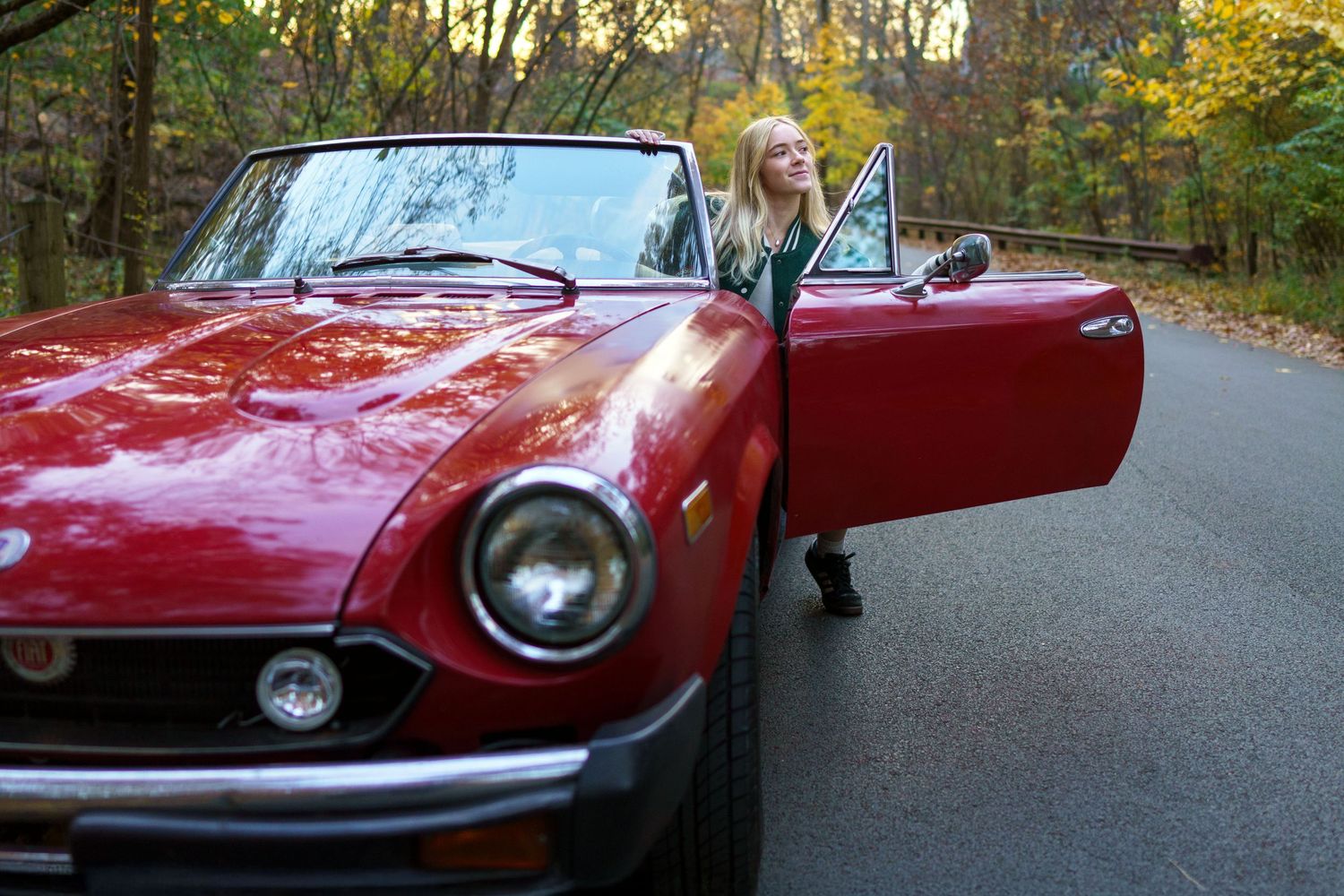 Senior entering vintager car down fall colored lane in Clintonville, Ohio by Jamie Macey Photography