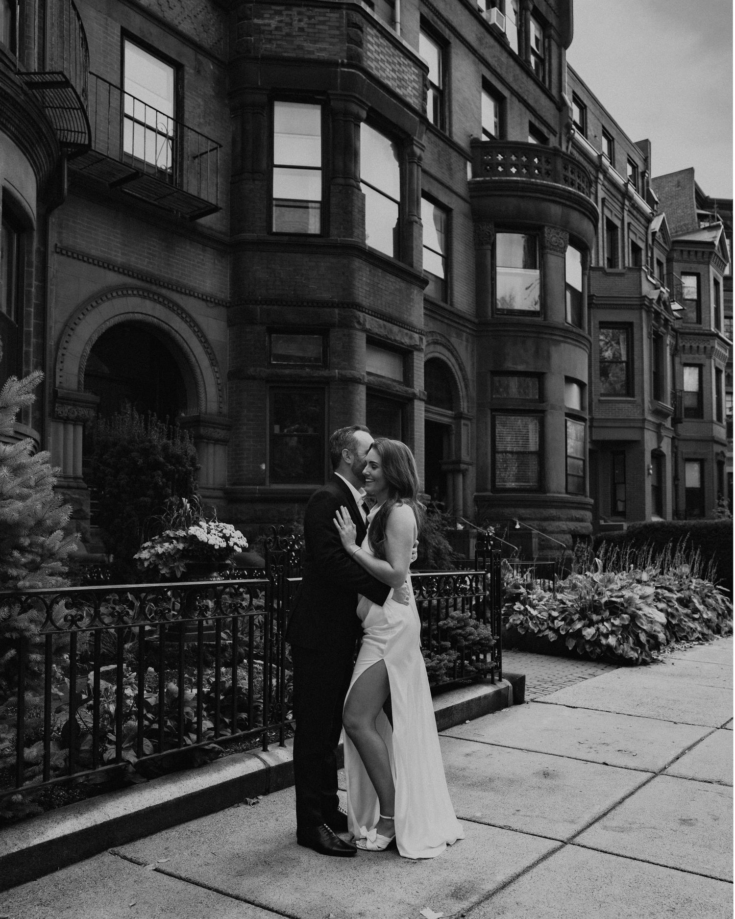 A series of black and white artistic wedding photos showing a couple sharing tender moments along brownstone steps and railings.