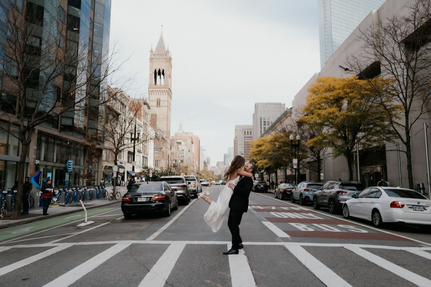 City skyline view with couple silhouetted against crosswalk and modern buildings.